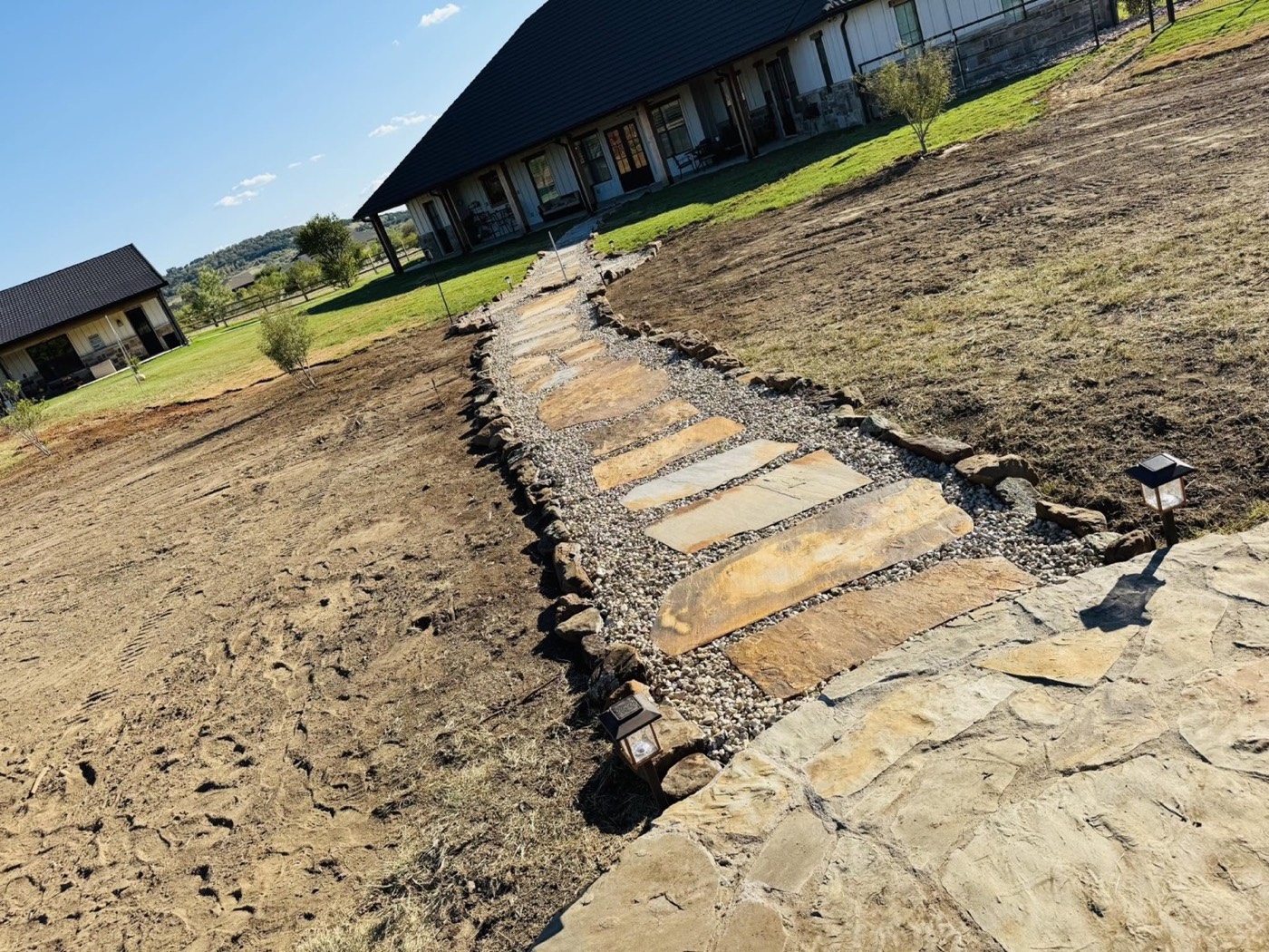 Stone walkway installation in progress across the yard