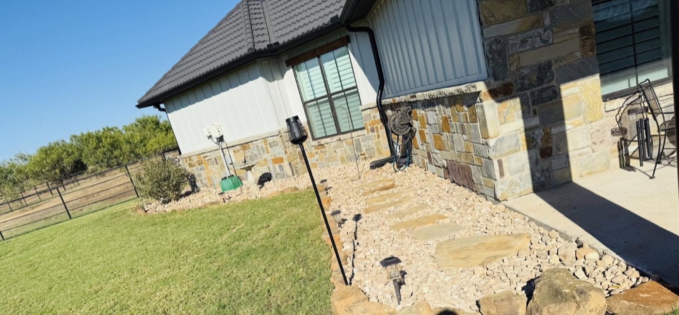 Finished rock and planting bed beside the house