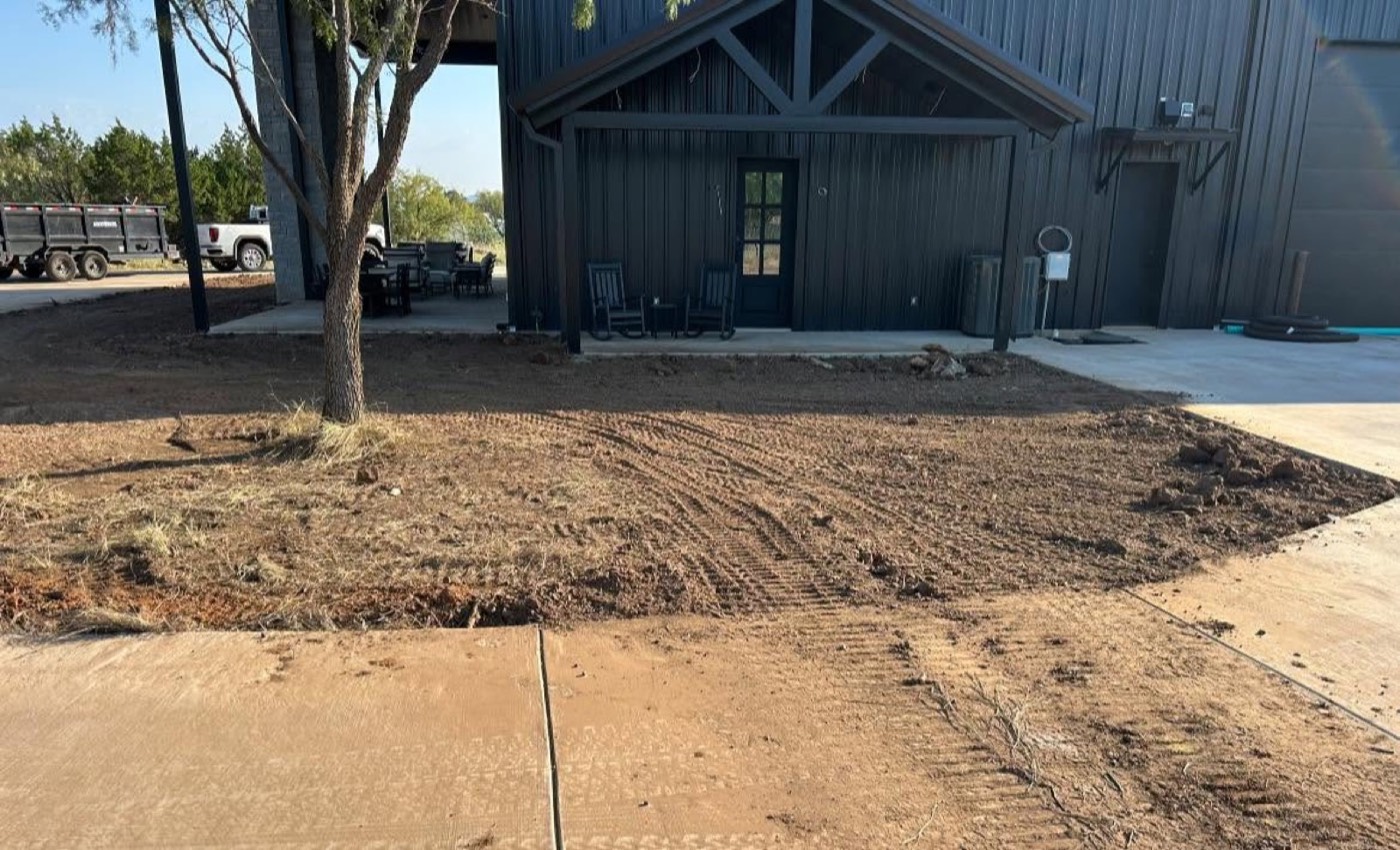 Before: bare soil around a home before landscape installation