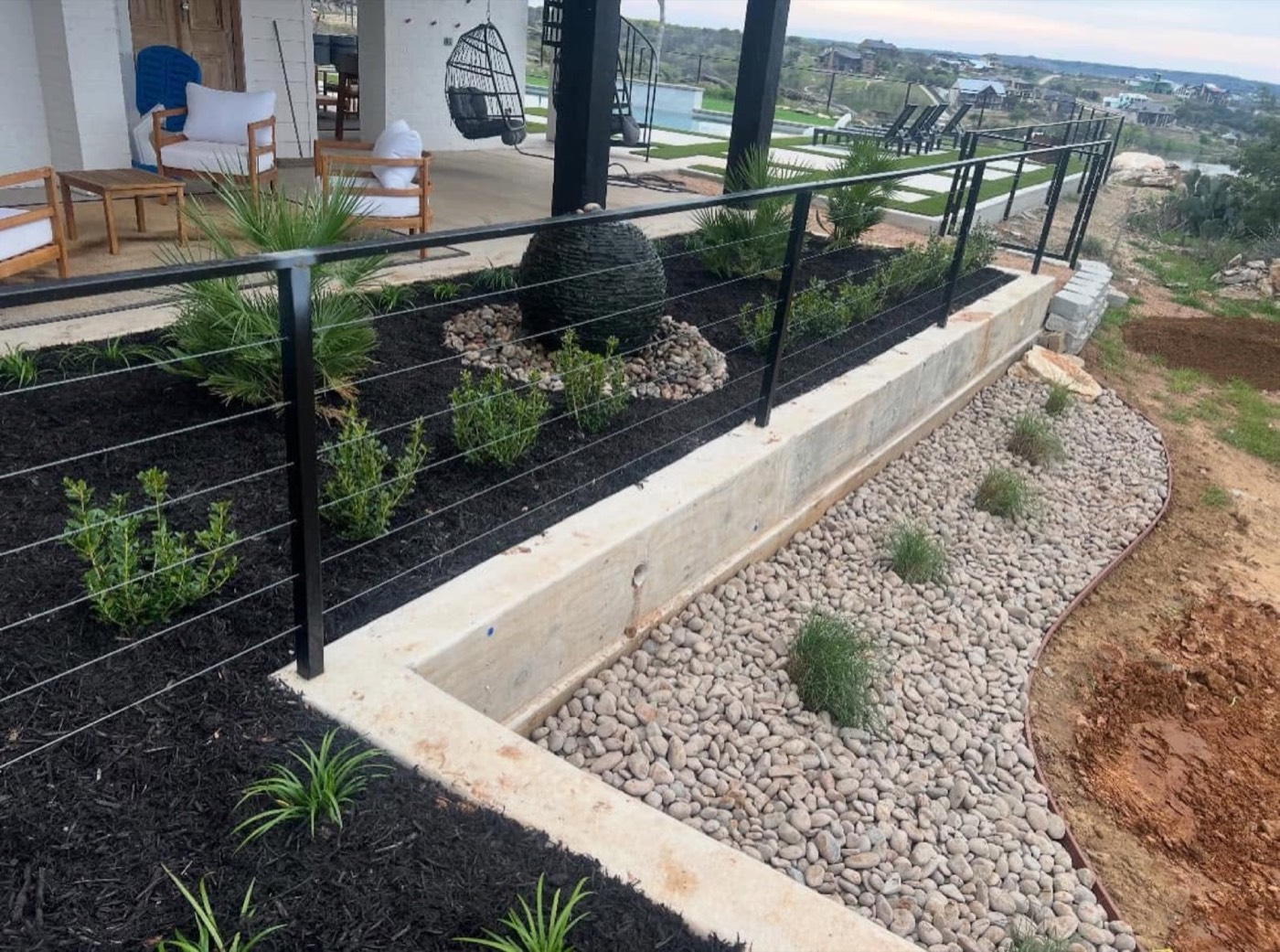 Finished rock landscaping with shrubs and decorative stone