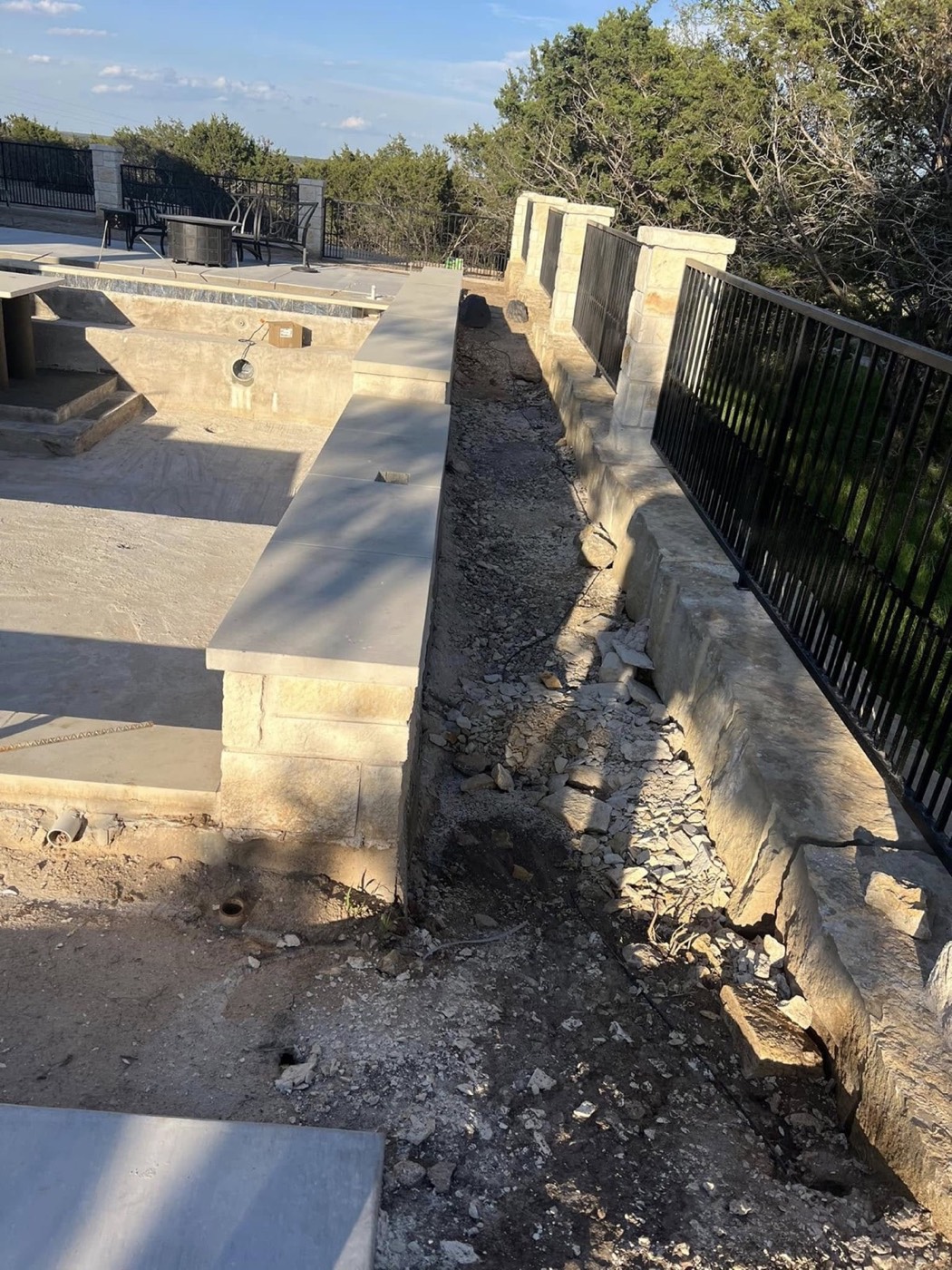 Before: bare landscape strip beside the pool and stone patio