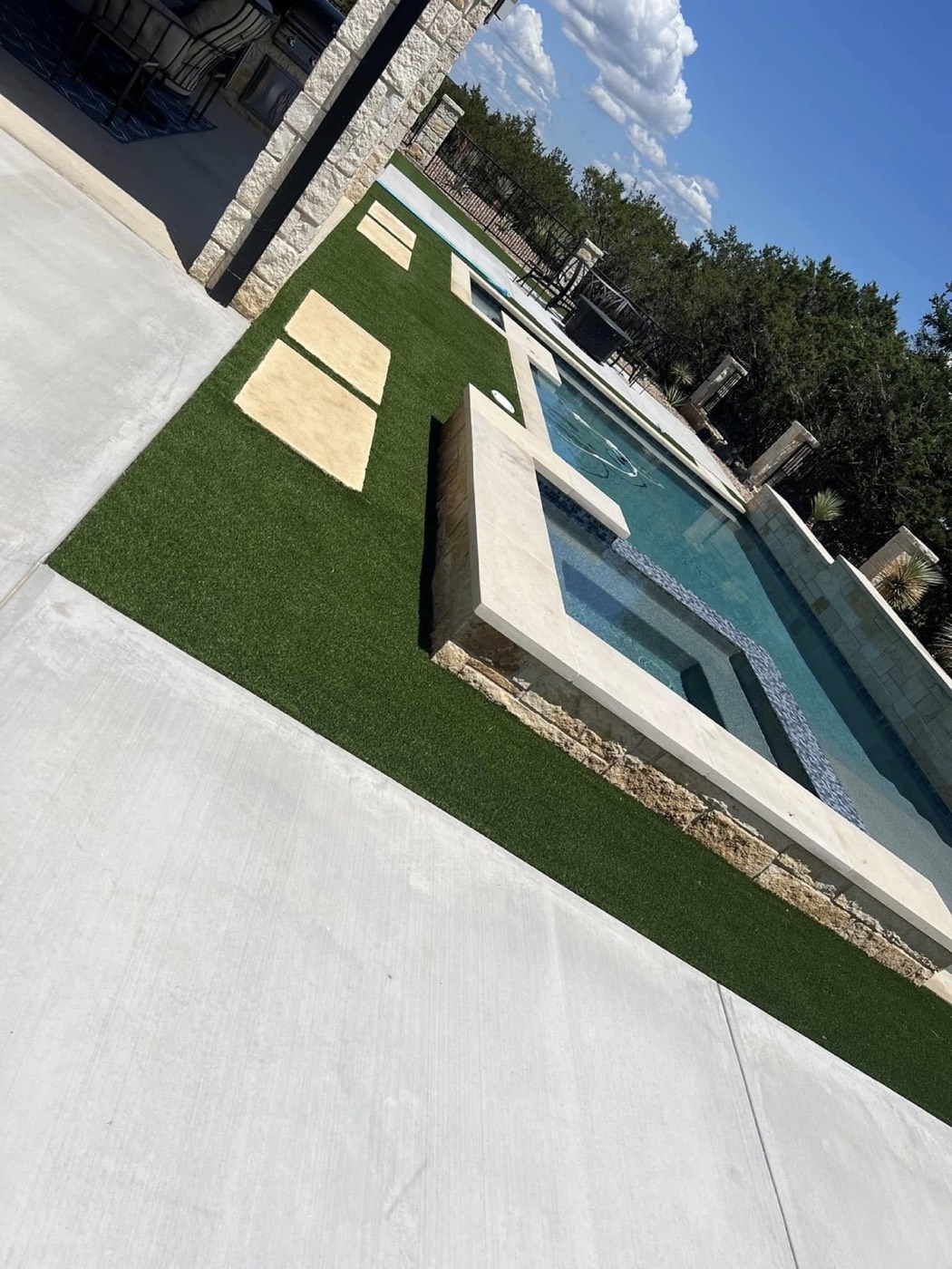Additional view of the pool, turf, and decorative rock landscape
