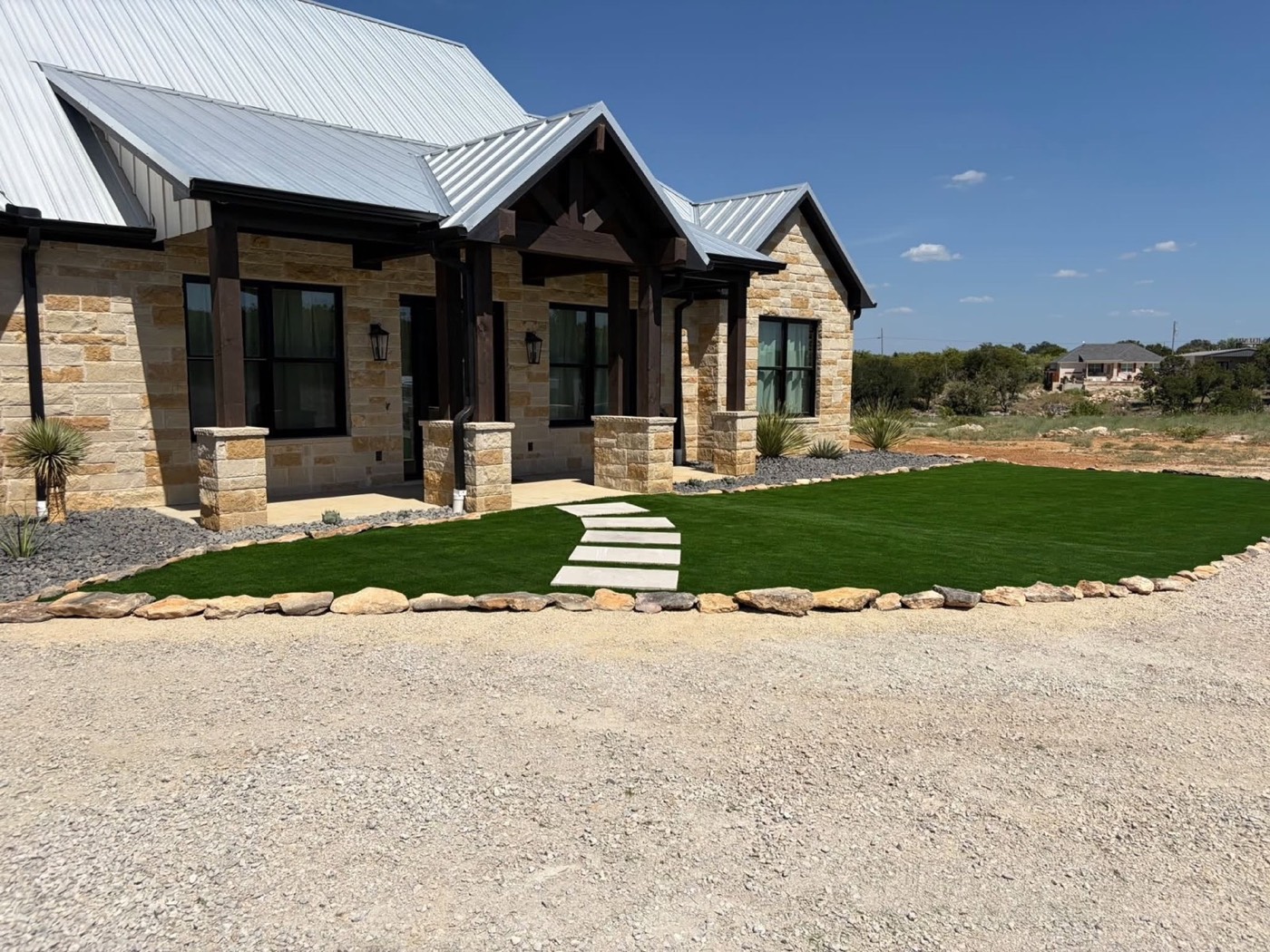 Green turf edged with gravel beside a modern home