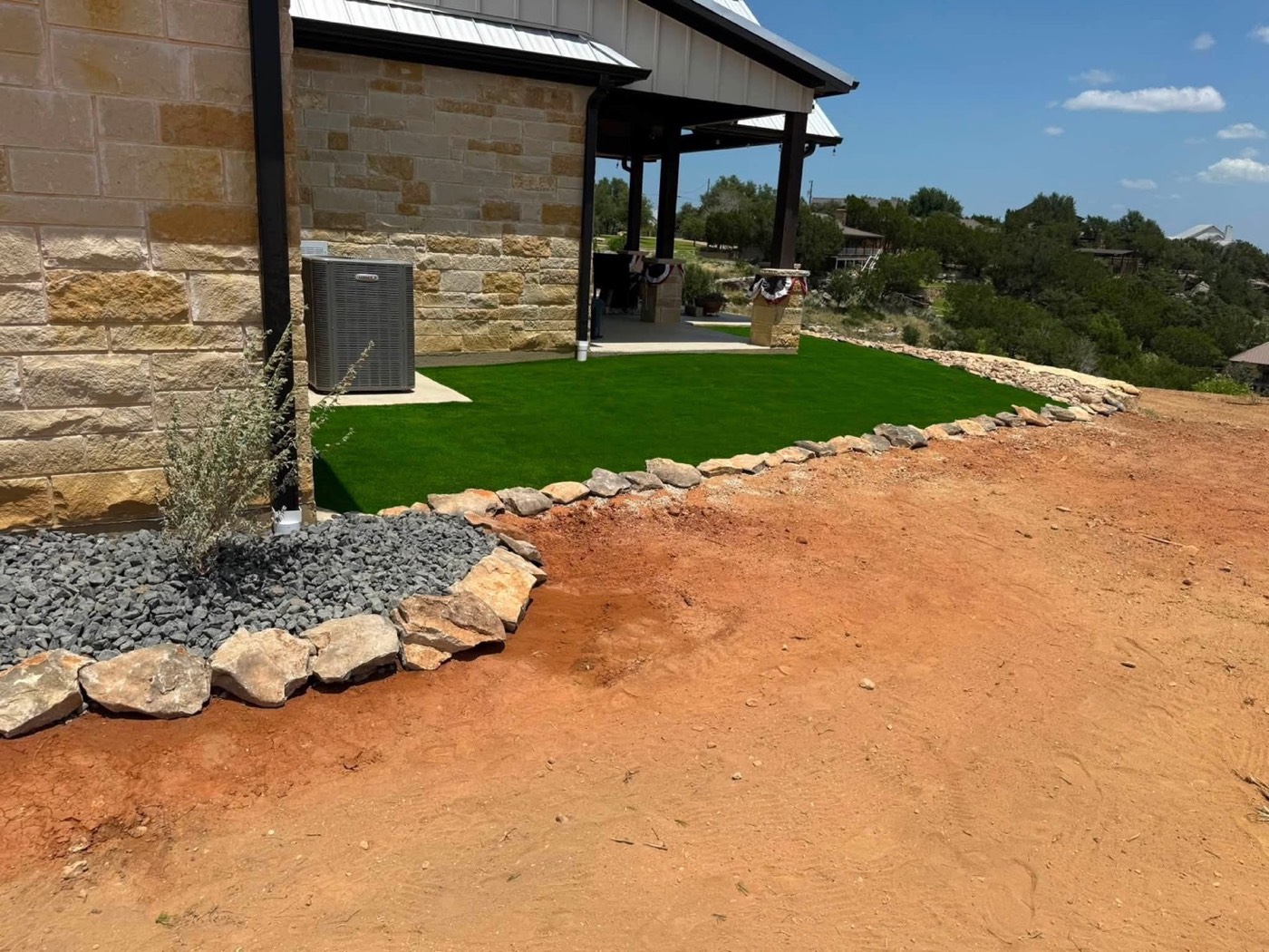 Turf with curved stone edging and a landscape bed